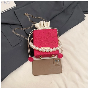 Close-up of floral lace mini bag with pearl handle and metal chain for size reference