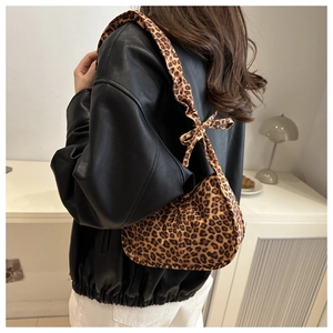 Close-up of leopard print baguette bag with a stylish bow knot on shoulder strap
