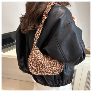 Detail showing the pleated scrunchie handle and retro leopard print hobo bag on shoulder
