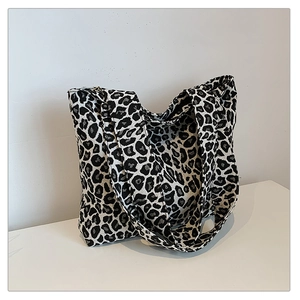 Close-up of leopard print canvas tote bag showing high-density woven texture and shoulder strap