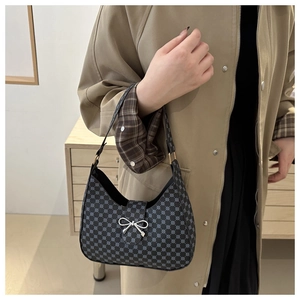 Detail of vintage patterned shoulder bag with silver metallic bow and blue ring texture