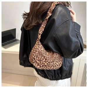 Chic hobo bag with leopard print fabric and ruffled shoulder strap shown on model