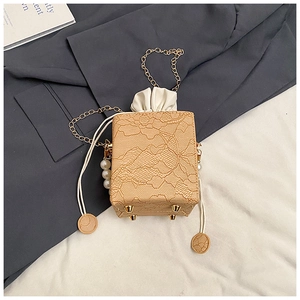 Detail of apricot lace box bag with flower embroidery, gold chain and pearl accent
