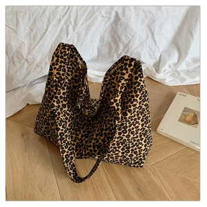 Detail of leopard print tote bag texture and wide strap on minimalist fabric background