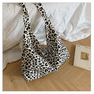 Detail of soft black and white leopard print canvas tote bag on a cozy home background