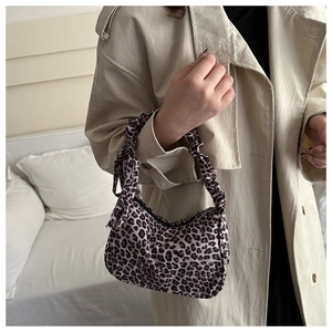 Detail of leopard print shoulder bag with scrunched handle and decorative ribbon tie