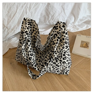 Detail shot of large leopard print tote bag on wooden floor with modern magazine