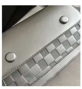 Macro detail of silver checkered pattern bag with faux leather texture and round buttons