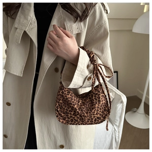 Close-up of leopard print crescent bag with ruched handle and knot detail