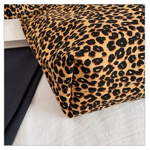 Detailed macro view of the leopard print canvas fabric texture and bottom stitching