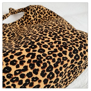 Close-up detail of leopard print canvas fabric and stylish knotted handle design