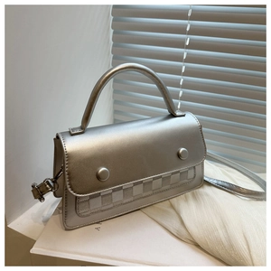 Macro view of silver matte rectangular handbag with checkered texture and circular buckles