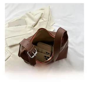 Interior detail of large brown leather tote bag showing spacious capacity for two phones