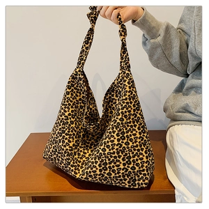 Detail of leopard print canvas tote bag featuring a stylish knotted shoulder strap design
