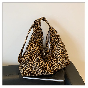 Detail of leopard print canvas tote bag featuring decorative knot handles and soft texture