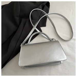 Top view of a metallic silver rectangular crossbody bag with flap and long shoulder strap