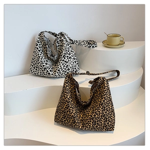 Detail of leopard print tote bags in black-white and brown-black colors on white steps