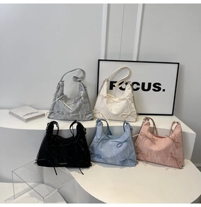Détail de sacs hobo colorés ornés de nœuds avec bandoulières à chaîne en métal