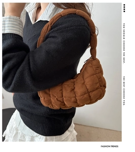 Détail du sac sous l'aisselle matelassé marron avec texture en daim et coutures