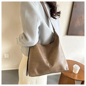 Detail of vintage brown PU leather hobo bag with soft textured pleated finish
