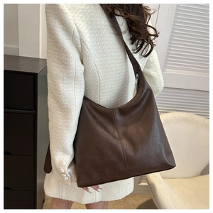 Model wearing dark brown PU leather hobo bag showing spacious design and wide strap