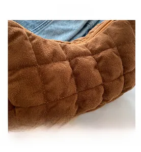 Gros plan détaillé sur le tissu matelassé marron et la fermeture éclair du sac à main