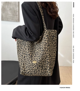 Détail du sac cabas en nylon léopard montrant le logo fait main et la coupe d'épaule