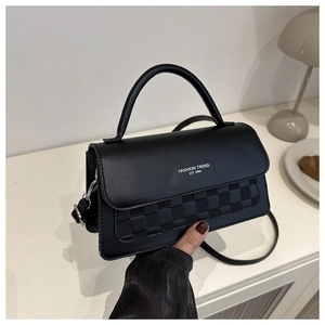 Detail of black baguette bag with checkerboard pattern and fashion trend print