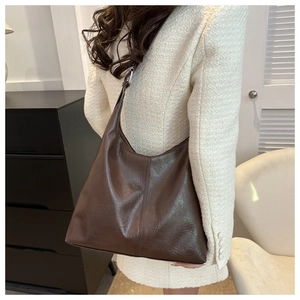 Detail view of a large dark brown tote bag with soft leather texture and stylish stitching