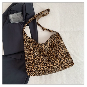 Fashionable leopard print canvas tote bag with long strap shown in an urban casual style
