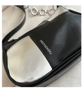 Close-up of black and silver PU leather bag with metal chain and fashion lettering