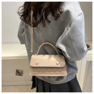 Minimalist beige crossbody bag with checkered texture shown on a female model