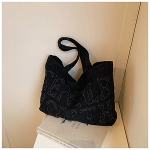 Dettaglio borsa tote in denim nero vintage con lettere FEMALE YOUTH a bordi sfilacciati
