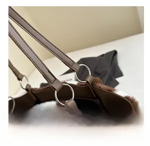 Detail of metal ring hardware connecting cow print plush fabric and brown leather strap
