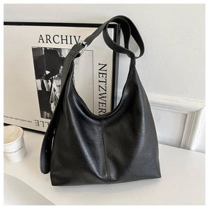 Detail of black large-capacity PU leather bucket bag with adjustable shoulder strap texture