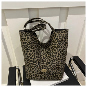 Gros plan d'un sac cabas léopard avec plaque en métal fait main sur une chaise chic