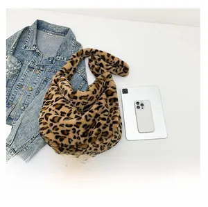 Detailed view of leopard print plush shoulder bag shown with tablet for size reference