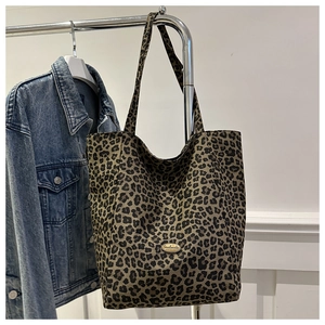 Détail du sac cabas en nylon léopard avec plaque métallique handmade ovale sur le devant