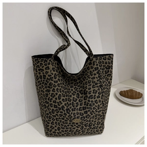 Détail du sac cabas léopard avec logo métallique fait main et texture nylon canvas