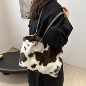 Détail du sac à bandoulière en peluche à motif vache avec lanière en cuir