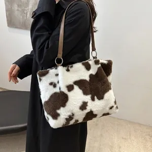 Detailed side view of large cow print faux fur tote bag showing fluffy texture and strap