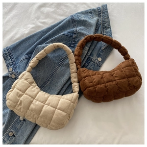Close-up of beige and dark brown quilted shoulder bags featuring a puffy square-stitch texture