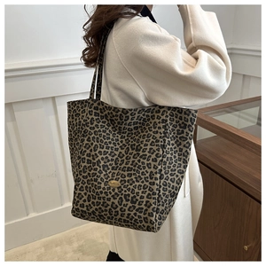 Détail du sac cabas léopard avec logo métallique et large bandoulière en toile résistante