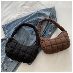 Detailed close-up of quilted puff shoulder bags in black and dark brown on denim