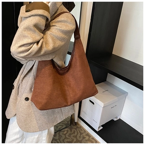 Brown suede hobo tote bag shown on model featuring a minimalist vintage half-moon design