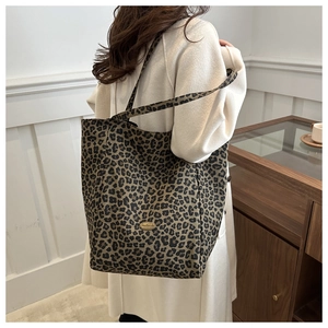Détail du sac cabas en nylon léopard avec plaque logo dorée handmade et bandoulière épaule