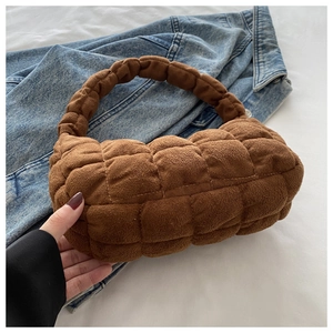 Close-up of brown quilted faux suede handbag with soft texture and stitching detail