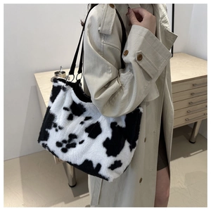 Model wearing a cow print plush shoulder bag with high-quality soft faux fur texture