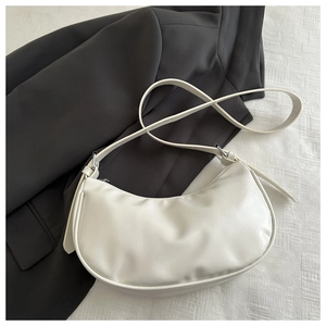 Detail of white crescent moon bag in textured leather with silver hardware and strap