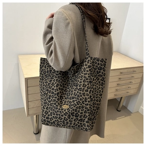 Détail du grand sac cabas à motif léopard avec plaque métallique dorée faite à la main